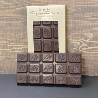 Bourbon Dark Chocolate bar on its side in front of chocolate bar in gold box