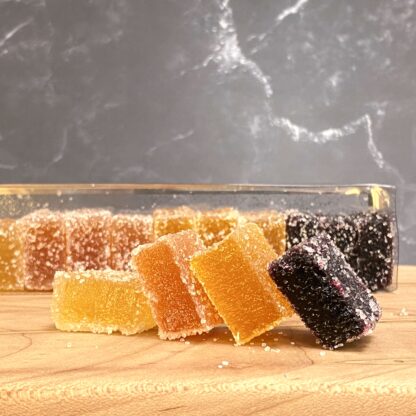 Muscadine, Peach, Satsuma, and Blueberry pate de fruit squares on a cutting board