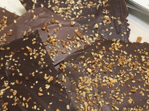 4 types of toffee, each covered with a different chocolate and crushed pecans. Shows the variety of color in the chocolate we use