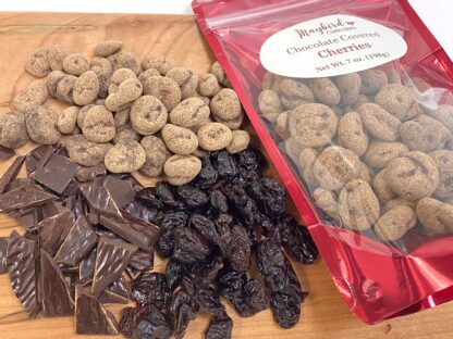 Chocolate covered cherries with dried cherries and chopped chocolate on a cutting board